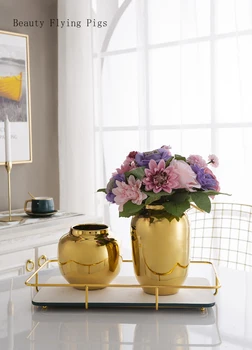 Namo gyvenamasis kambarys TV kabinetas, vyno kabinetas aukso dekoratyviniais ornamentais vaza paprasta kūrybos sidabro gėlė, gėlė inserter minkštas meno